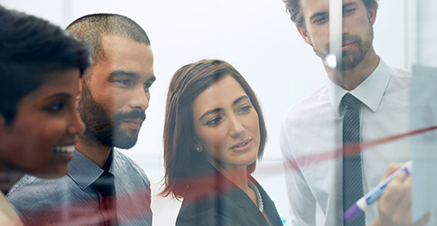  woman drawing on board with business team