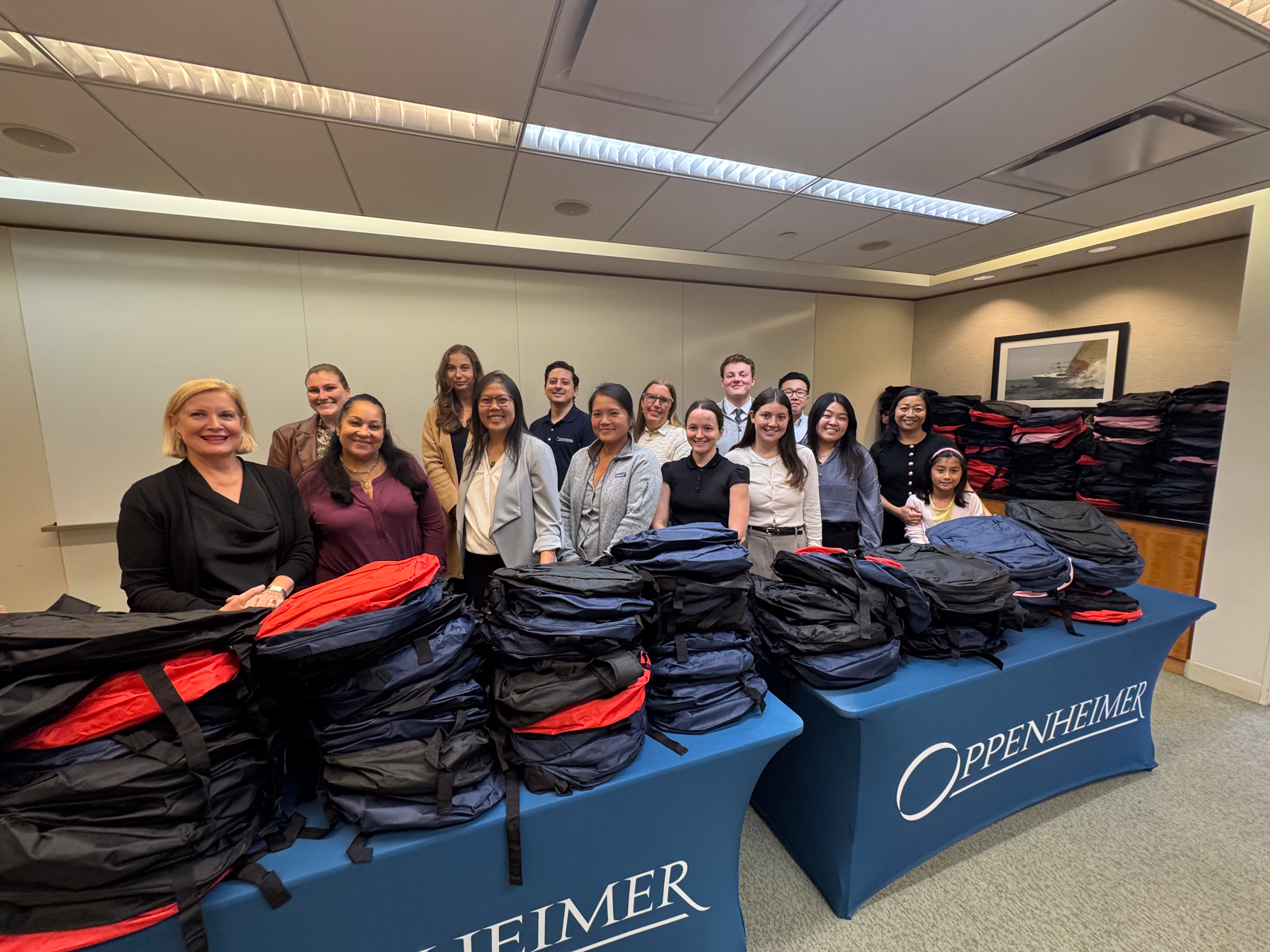 Oppenheimer employees packing donated school supplies into brand-new backpacks for students